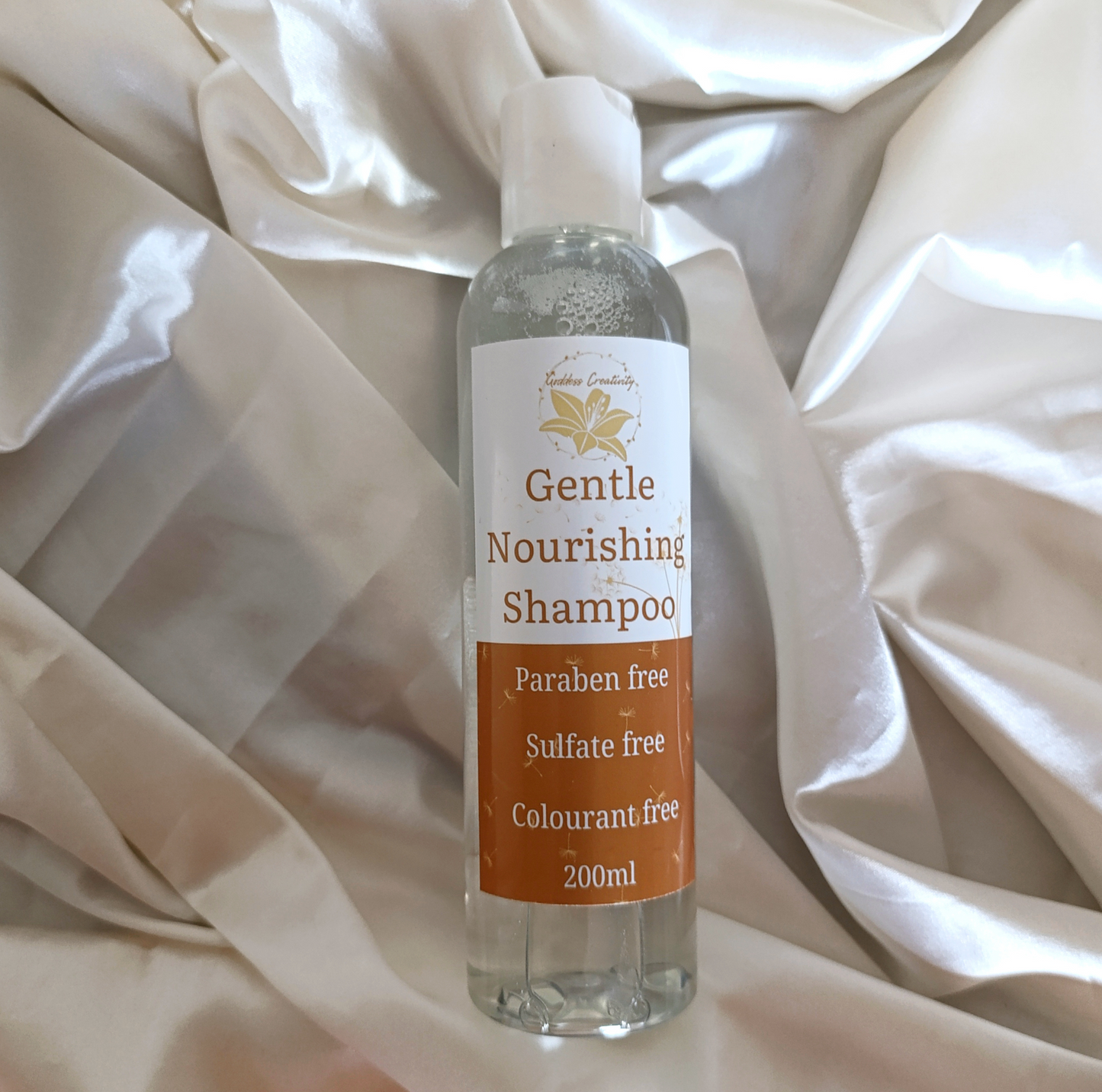 Goddess Creativity Gentle Nourishing Shampoo – paraben-free, sulfate-free, and colourant-free formula in a 200ml clear bottle, photographed on silky cream fabric.